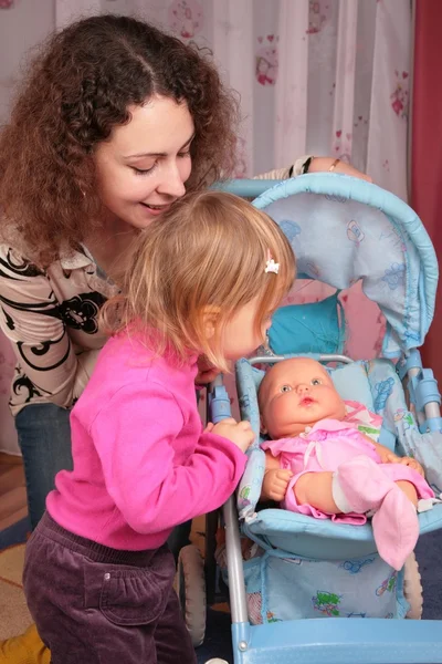 Mor och liten flicka med dockan i vagnen — Stockfoto