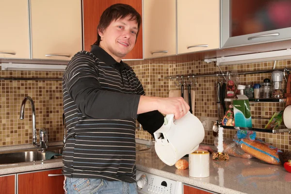 Man en waterkoker op de keuken — Stockfoto