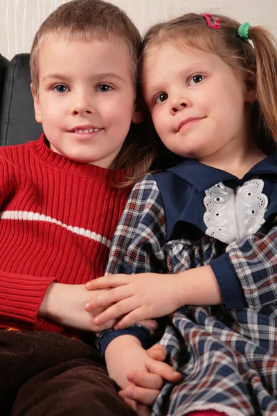 Двоє дітей сидять на дивані, тримаючи руки — стокове фото