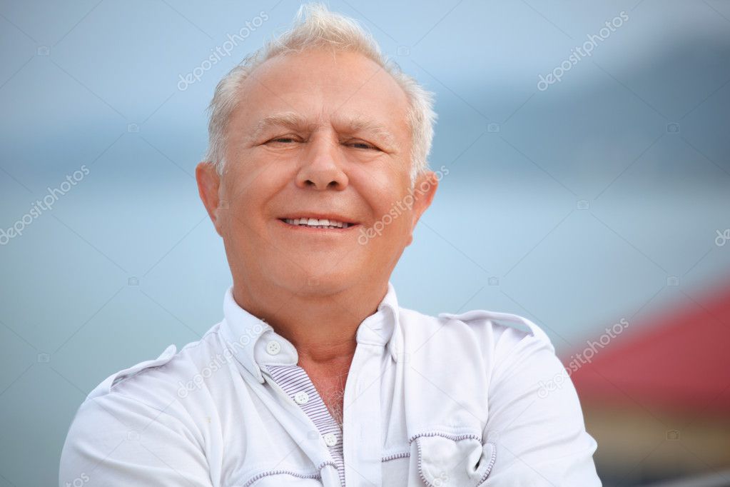 Smiling senior near seacoast against mountain