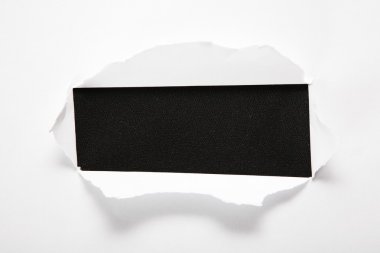 The sheet of paper with the rectangular hole against the black background clipart