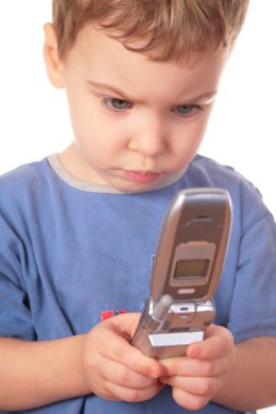 Little girl looks on cell phone clipart