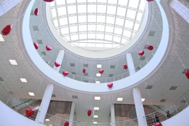 Interior of commercial center, decorated with infatable hearts clipart