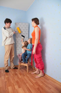 Children help parents to glue wall-papers clipart