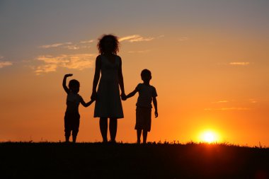 Anne ve çocuklar günbatımı üzerinde