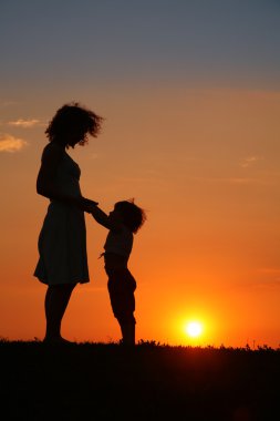 Mother and daughter on sunset clipart