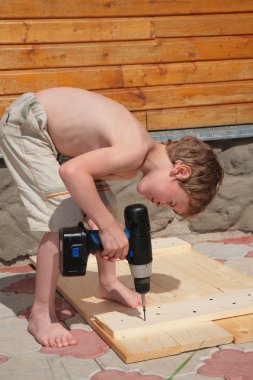 Boy drills an electrodrill clipart