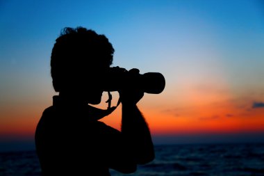 Silhouette of photographer ashore on sunset clipart