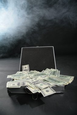 Suitcase with dollars against smoke clipart