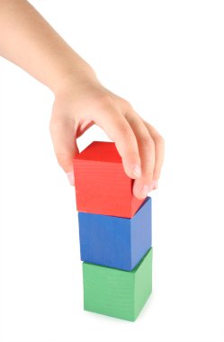 Children's hand and toy cubes clipart