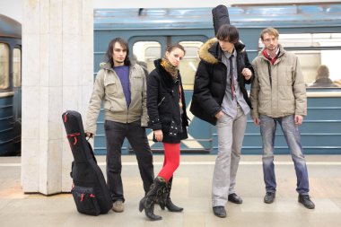 Four young musicians at metro station clipart