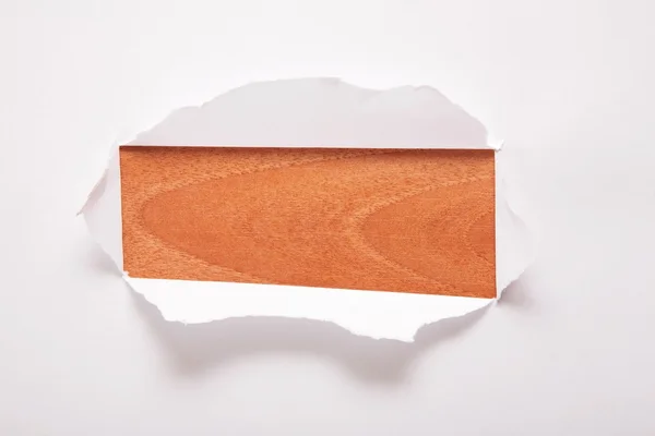 A folha de papel com o furo retangular contra o fundo de madeira — Fotografia de Stock
