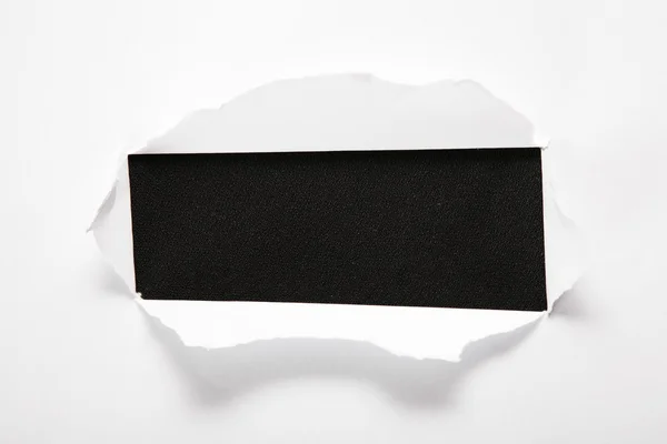 The sheet of paper with the rectangular hole against the black background — Stock Photo, Image