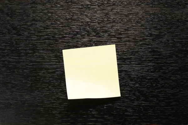 Gelber Papieraufkleber auf schwarzem Hintergrund — Stockfoto