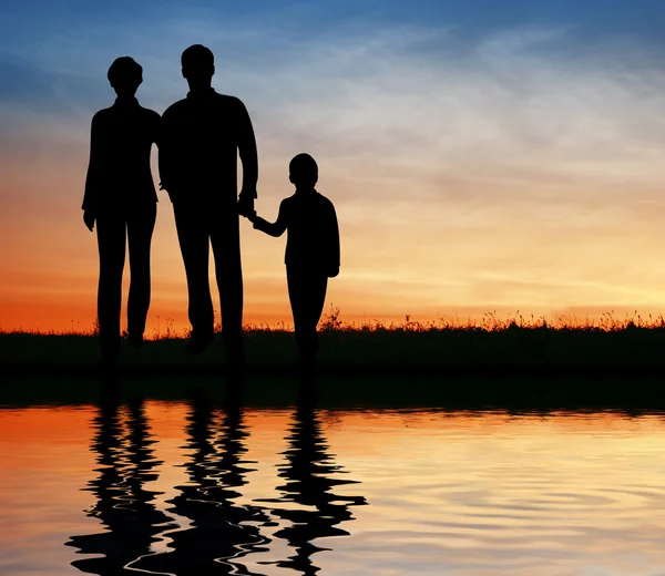 Famiglia silhouette sulla costa del tramonto — Foto Stock