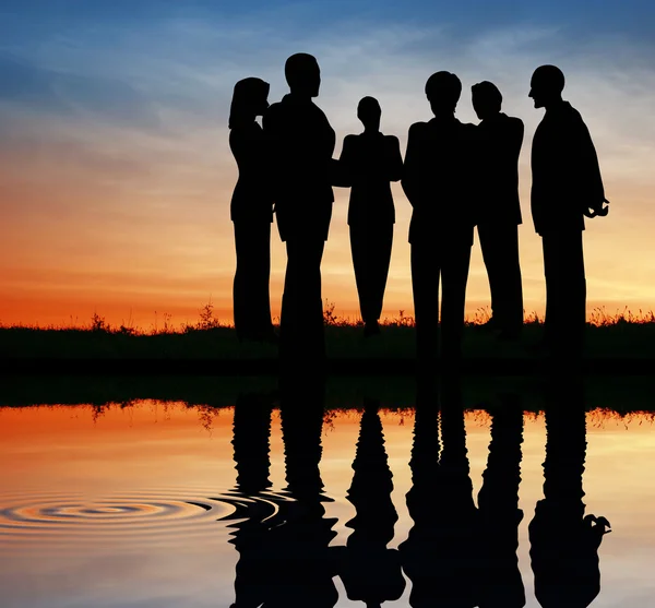 Silhouet zakelijke team. zonsondergang water — Stockfoto