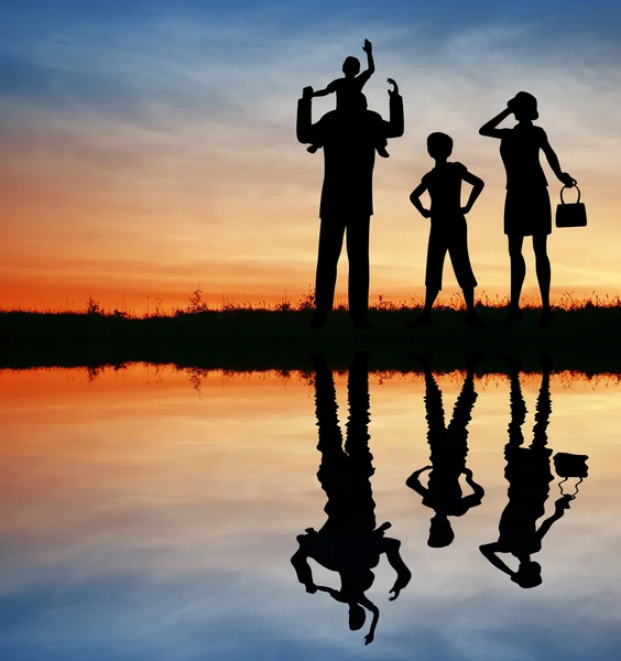 Familie silhouet op zonsondergang hemel. water — Stockfoto