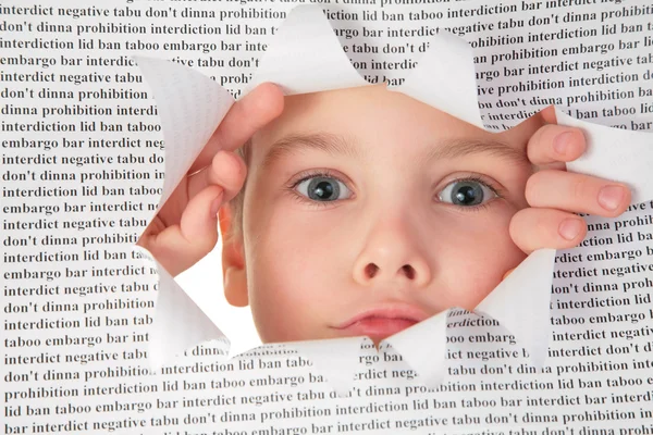 Boy looks into the hole in the sheet of paper with the text — Stock Photo, Image