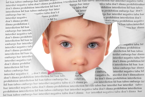 Bambino guarda nel buco nel foglio di carta con il testo — Foto Stock