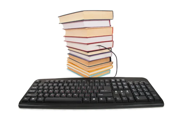 Стопка книг с подключенной черной клавиатурой — стоковое фото