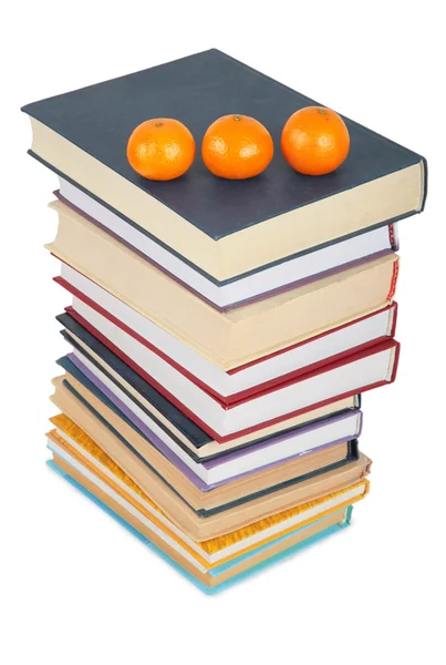 Куча книг с тремя мандаринами — стоковое фото