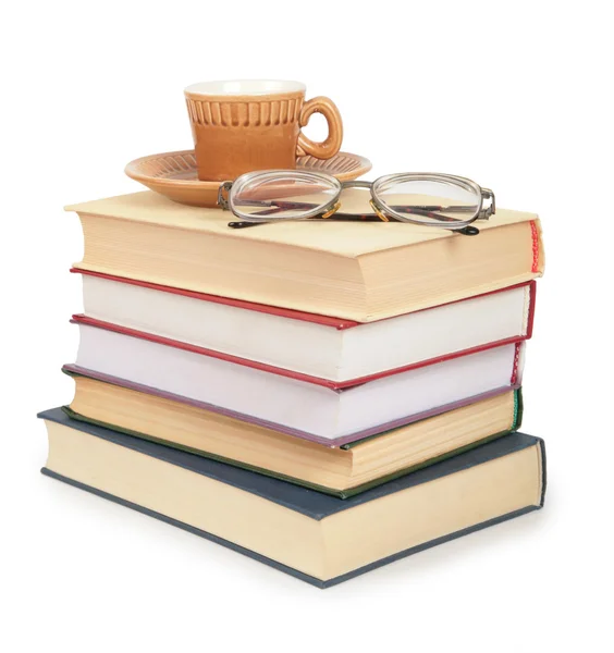 Kaffekopp och glasögon på högen av bok — Stockfoto