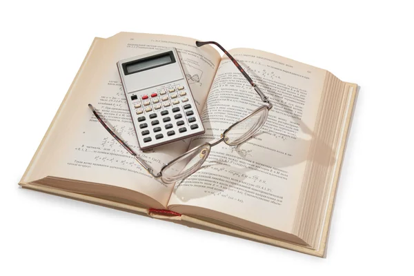 Calculadora e óculos na abertura do livro didático — Fotografia de Stock