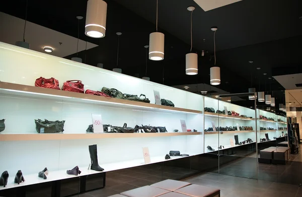 Planken in opslag met tassen en schoenen — Stockfoto