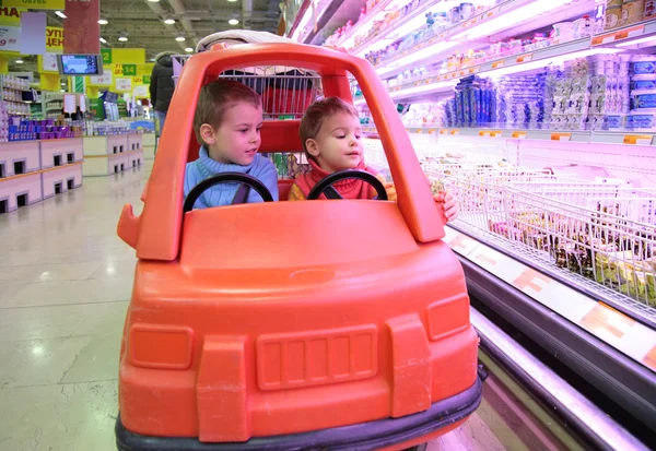 Діти в іграшковому автомобілі в супермаркеті 3 — стокове фото