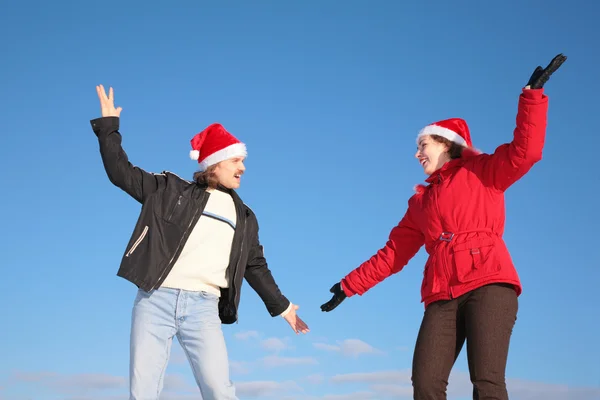 Couple dance in santa claus hats against blue sky — Stock Photo, Image