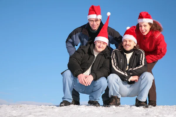 Четверо друзей на вершине снежного холма — стоковое фото