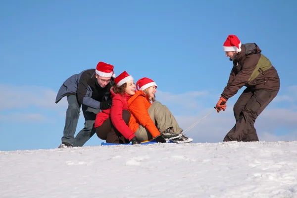 One man pull two girls on sled, other man push them — Stock Photo, Image