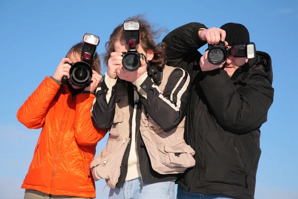 Three photographers against blue sky — Stock Photo, Image