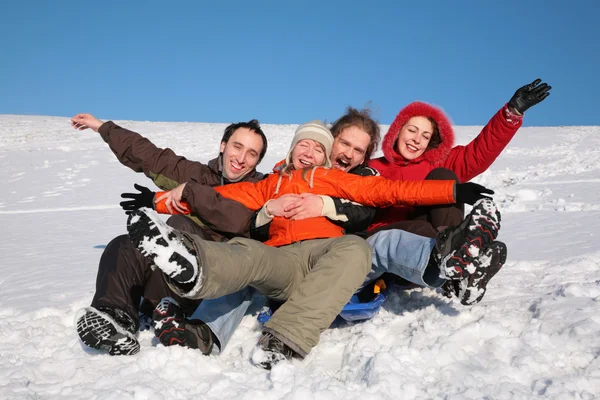 Группа друзей сидят на пластиковых санях на снегу 2 — стоковое фото