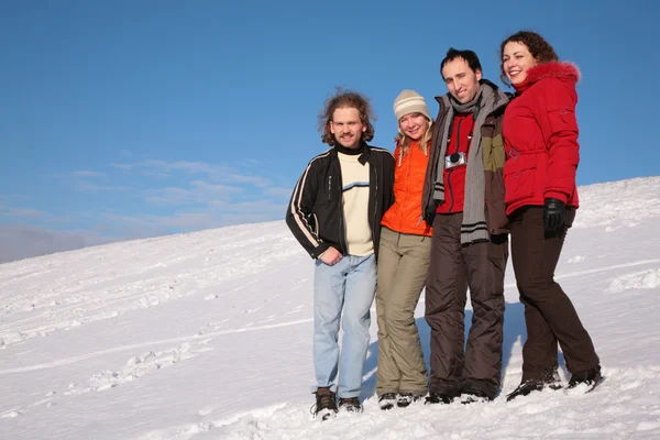 Grupo de amigos de pie en la nieve en la ladera —  Fotos de Stock