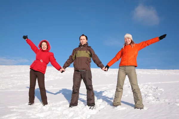 Tre vänner stå på snö på sluttning — Stockfoto