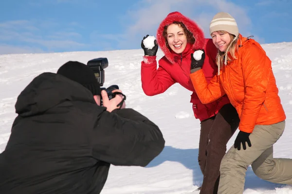 Dvě dívky házet sníh do fotograf — Stock fotografie