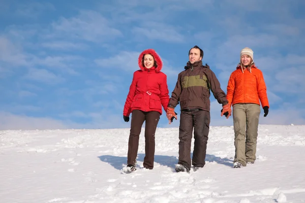 Tres amigos caminan sobre la nieve en la ladera 2 — Foto de Stock