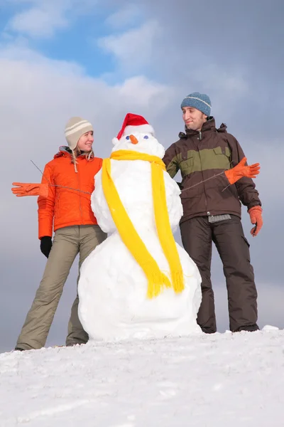 Pareja con muñeco de nieve en santa claus hat —  Fotos de Stock