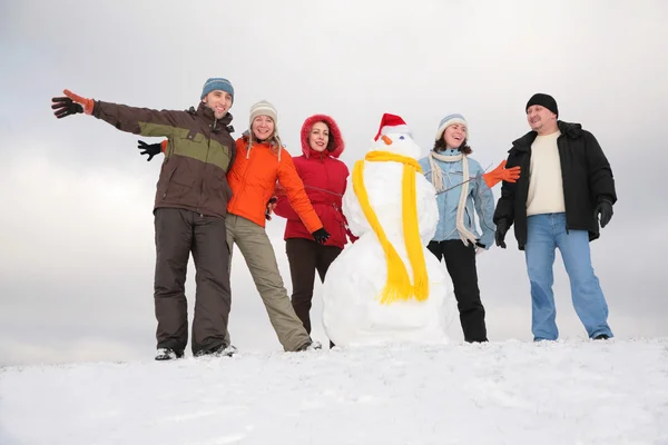 Groupe d'amis avec bonhomme de neige — Photo