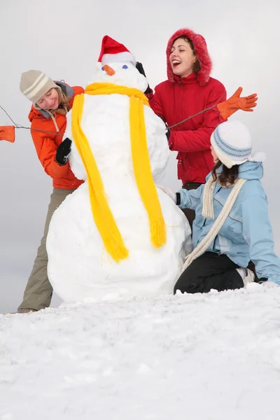 Τρεις κοπέλες και χιονάνθρωπος — Φωτογραφία Αρχείου