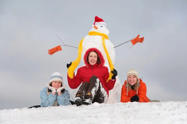 Τρία κορίτσια και χιονάνθρωπο σε καπέλο του Αϊ-Βασίλη — Φωτογραφία Αρχείου