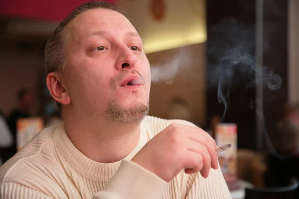Fumar homem libera fumaça da boca — Fotografia de Stock