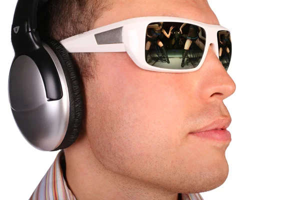 Jovem com óculos de sol e fones de ouvido meio virados — Fotografia de Stock