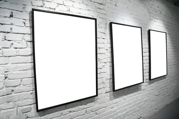 Três quadros na parede branca de tijolo — Fotografia de Stock