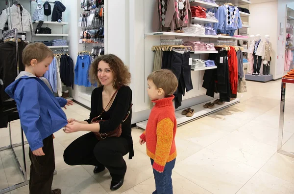 Moeder met kinderen in kledingwinkel — Stockfoto
