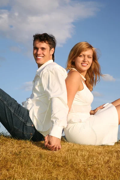 Couple assis sur la prairie dos à dos — Photo
