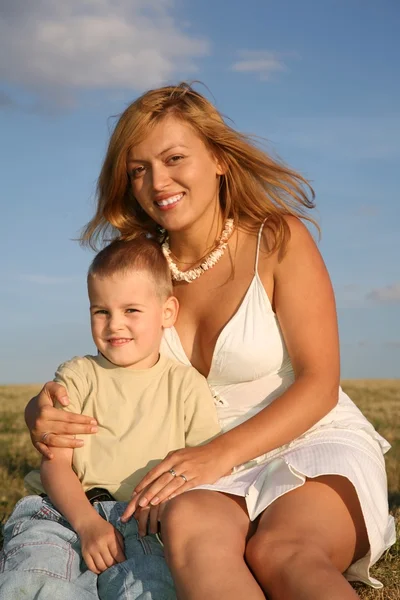 Anne ve oğlu çayır üzerinde oturmak — Stok fotoğraf