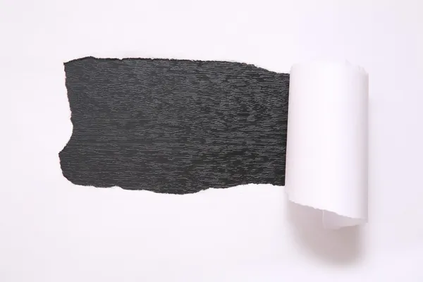 Das Blatt zerrissenes Papier vor schwarzem Hintergrund — Stockfoto