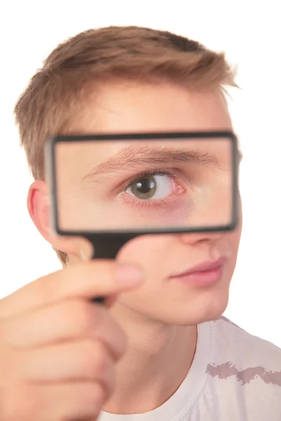 Man looks through magnifier — Stock Photo, Image